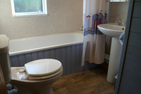 Billede af et badeværelse med badekar, toilet og håndvask i et chalet kaldet Five Waterings, Storbritannien.