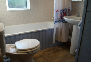 Billede af et badeværelse med badekar, toilet og håndvask i et chalet kaldet Five Waterings, Storbritannien.