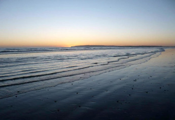 Atardecer sobre el mar visto desde la playa de Rainbow Petty Lodge en el Reino Unido, tranquilo y sereno.