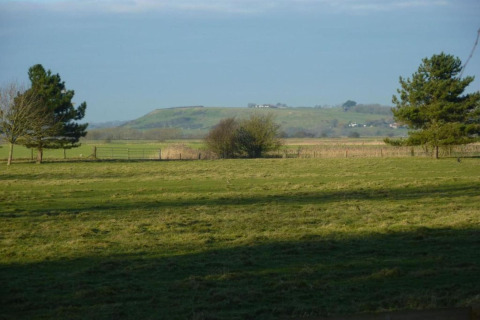 Veduta di campi verdi e colline dal Rainbow Petty Lodge nel Regno Unito, circondato da alberi.