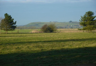 Veduta di campi verdi e colline dal Rainbow Petty Lodge nel Regno Unito, circondato da alberi.