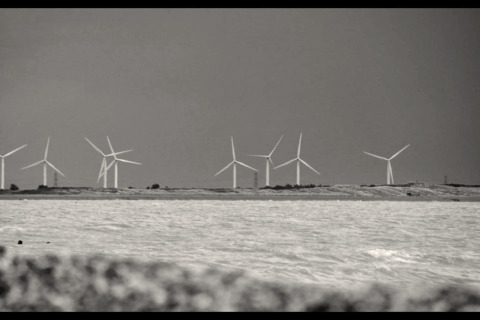 Foto en blanco y negro de aerogeneradores en la costa tomada desde Rainbow Petty lodge en Reino Unido.