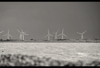 Foto en blanco y negro de aerogeneradores en la costa tomada desde Rainbow Petty lodge en Reino Unido.