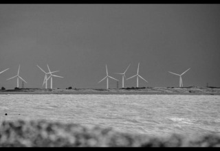 Foto in bianco e nero di turbine eoliche sulla costa, scattata da Rainbow Petty lodge nel Regno Unito.