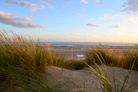 Vista de playa con dunas y pasto al atardecer desde Rainbow Petty lodge en el Reino Unido.