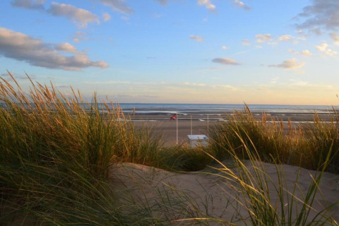 Vista sulla spiaggia con dune e erba al tramonto dalla Rainbow Petty lodge nel Regno Unito.