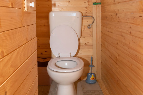 Badkamer met houten wanden en toilet in de Robinzonski Kamp Hofman bungalow in Kroatië.
