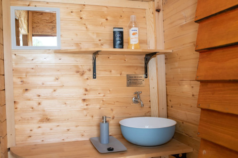 Houten wastafel met spiegel in de badkamer van Robinzonski Kamp Hofman - Private Bungalow, Kroatië.