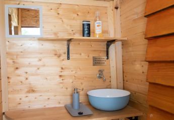 Mobile bagno in legno con lavabo e specchio al Robinzonski Kamp Hofman - Private Bungalow in Croazia.