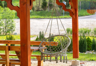 Buitenruimte met hangstoel en houten banken bij Robinzonski Kamp Hofman, privé bungalow in Kroatië