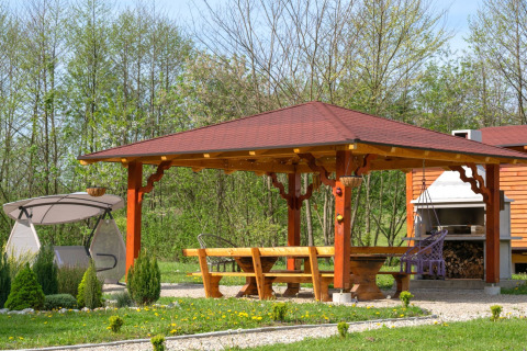 Overdekte houten prieel met bankjes, schommel, barbecue en tuin in Robinzonski Kamp Hofman, Kroatië.