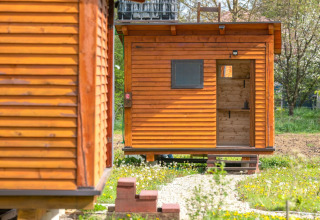 Houten bungalow bij Robinzonski Kamp Hofman, Kroatië, in groene omgeving met een eenvoudig ontwerp.