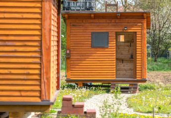 Bungalow in legno al Robinzonski Kamp Hofman, Croazia, circondato dal verde e dal design semplice.