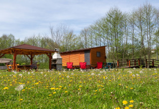 Knus mobiel huisje bij Robinzonski Kamp Hofman in Kroatië, omringd door bloemen en bomen.