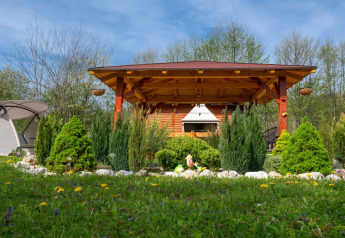 Bungalow privato con terrazza coperta e giardino rigoglioso al Robinzonski Kamp Hofman in Croazia, giornata di sole.