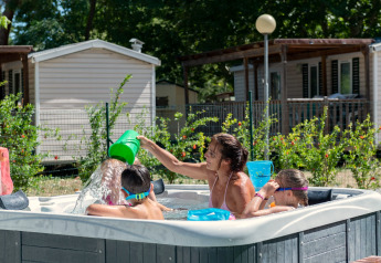 Gezin geniet van een bubbelbad voor de stacaravan Cottage 'Cesenatico' in Italië, kinderen spelen.