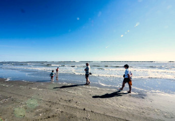 Mensen wandelen en spelen op het strand bij mooi weer nabij Cottage Cesenatico, Italië