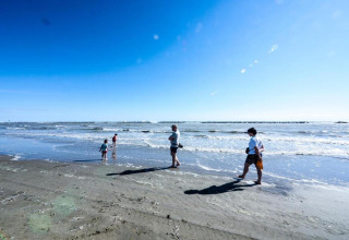 Personas caminan y juegan en la orilla del mar bajo el sol cerca del Cottage Cesenatico, Italia