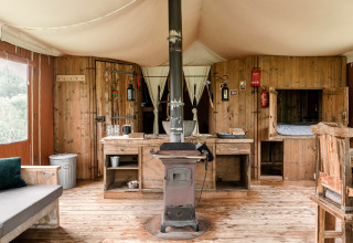 Rustiek houten interieur met kachel en keuken in Duynlodge - Duynpark, Nederland.