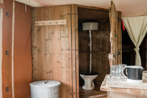 Bagno rustico con pareti in legno e wc visibile al Duynlodge - Duynpark nei Paesi Bassi.