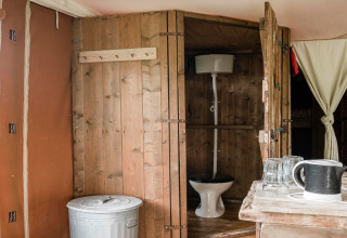 Bagno rustico con pareti in legno e wc visibile al Duynlodge - Duynpark nei Paesi Bassi.