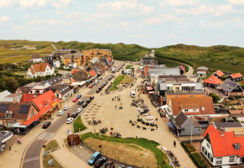 Aerial view of Duynlodge - Duynpark in the Netherlands with red-roofed buildings and green dunes.