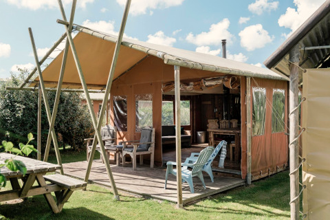 Glamping lodge met terras en tuinmeubilair bij Duynlodge - Duynpark in Nederland.