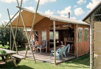Outdoor glamping lodge with terrace and garden furniture at Duynlodge - Duynpark in the Netherlands.