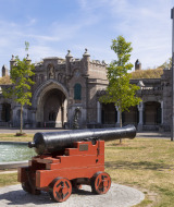 Un cañón histórico frente a la entrada de una fortaleza y una fuente en un parque cerca de Naarden, Holanda Septentrional.