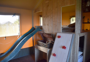 Area bimbi interna alla Kidz Lodge nei Paesi Bassi con scivolo, parete da arrampicata e zona letto.
