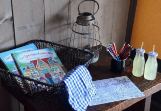 Table at Kidz Lodge in the Netherlands with books, coloring pencils, lantern, drinks and coloring sheet.