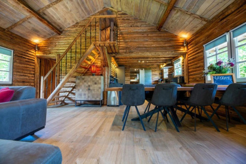 Indvendig af hyggelig bjælkehytte 'Paalchalet 723' i Belgien med træinteriør og moderne møbler.