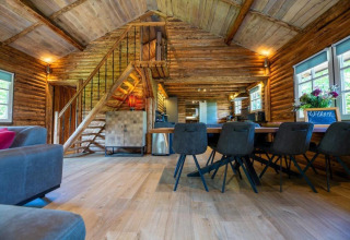 Indvendig af hyggelig bjælkehytte 'Paalchalet 723' i Belgien med træinteriør og moderne møbler.
