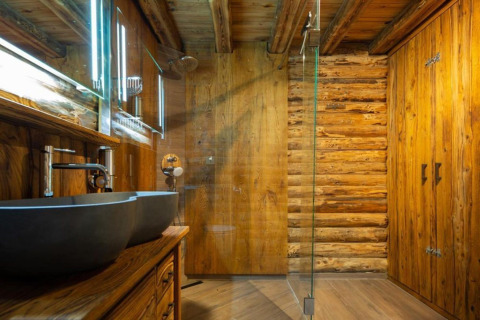Moderne badeværelse i træstil med dobbelte håndvaske, glasset bruser og spejle på Paalchalet 723 i Belgien.