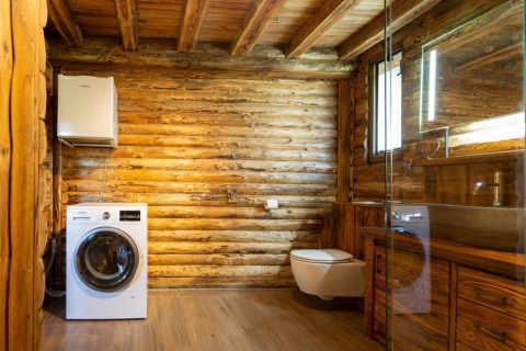 Moderne badeværelse i træhytte med vaskemaskine, væghængt toilet og spejl, Paalchalet 723, Belgien.