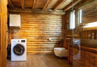 Moderne badeværelse i træhytte med vaskemaskine, væghængt toilet og spejl, Paalchalet 723, Belgien.