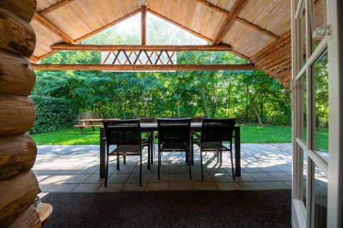 Udsigt fra indgangen til en hytte ved Paalchalet 723 i Belgien med terrassebord og stole i det grønne.