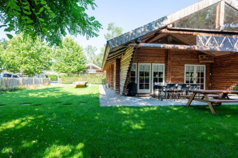 Trælodge med terrasse og grøn have ved Paalchalet 723 i Belgien, ideel til udendørs ophold.