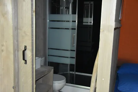 Badkamer en douche in Veluwe Lodge safaritent op Camping Samoza, Nederland, in moderne stijl.