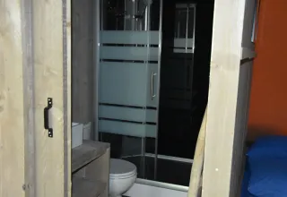 Baño y ducha en la tienda safari Veluwe Lodge en Camping Samoza, Países Bajos, con estilo moderno.