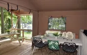 Safaritent van Veluwe Lodge op Camping Samoza in Nederland met houten terras en zitgedeelte buiten.