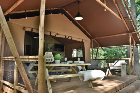 Safari tent Veluwe Lodge at Camping Samoza in the Netherlands with a wooden deck, seating, and nature view.
