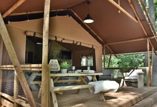 Safaritent Veluwe Lodge op Camping Samoza in Nederland met houten veranda, picknicktafel en zitgedeelte.
