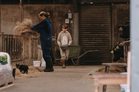 Una mujer y un niño alimentan animales en un establo de Feather Down De Oude Melkstal, North-Brabant, Países Bajos.