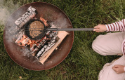 Persona che prepara popcorn su un fuoco all'aperto al parco vacanze Feather Down De Oude Melkstal, Brabante Settentrionale, Paesi Bassi.