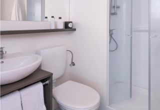 Moderne badkamer in een Glamping Family Plus safaritent bij Wecamp Cadaqués, met douche en handdoeken.