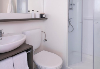 Bagno moderno in una tenda safari Glamping Family Plus a Wecamp Cadaqués, con doccia e asciugamani bianchi.