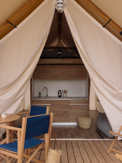 Interieur van een safaritent met comfortabele inrichting en sanitaire voorzieningen bij Wecamp Cadaqués, Spanje.