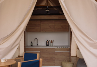 Interieur van een safaritent met comfortabele inrichting en sanitaire voorzieningen bij Wecamp Cadaqués, Spanje.