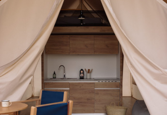 Interno di una tenda safari con arredi confortevoli e servizi igienici a Wecamp Cadaqués, Spagna.